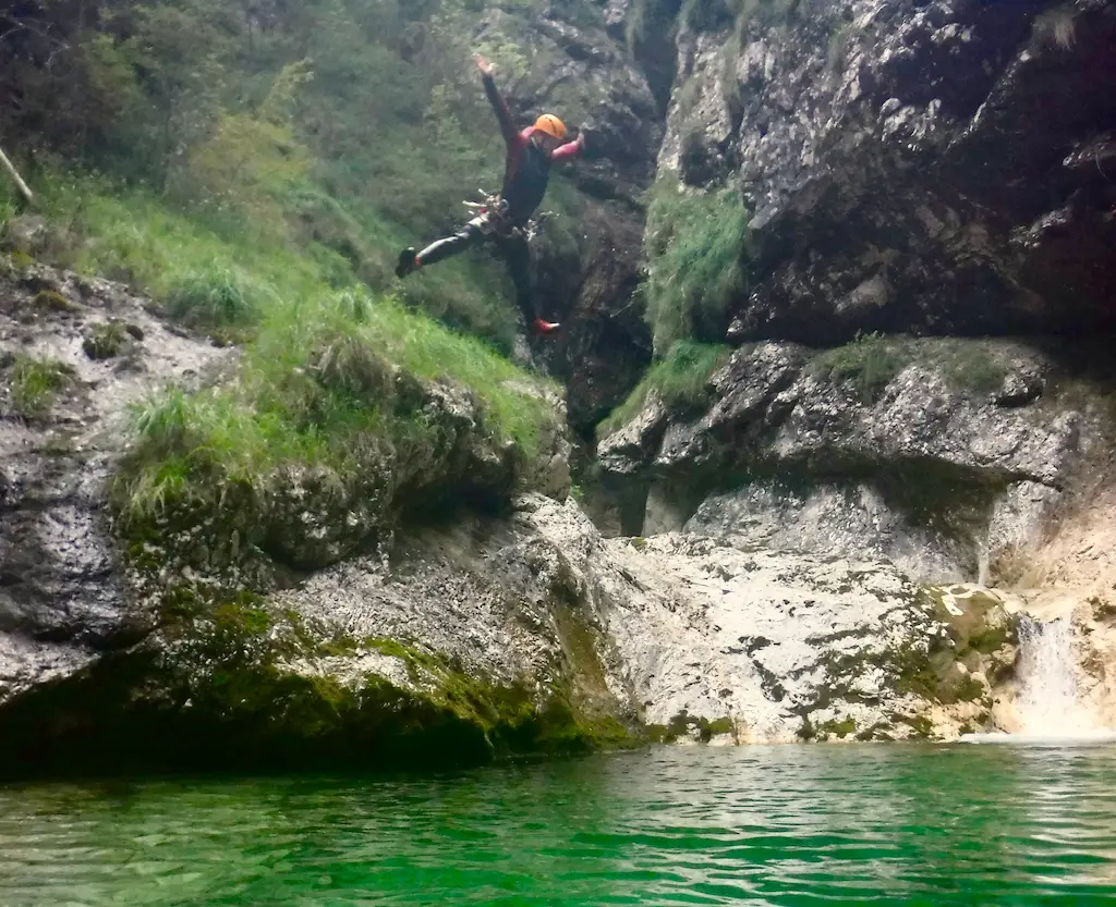 Canyoneer jumping into a plunge pool with outstretched arms – Friuli canyoning trip